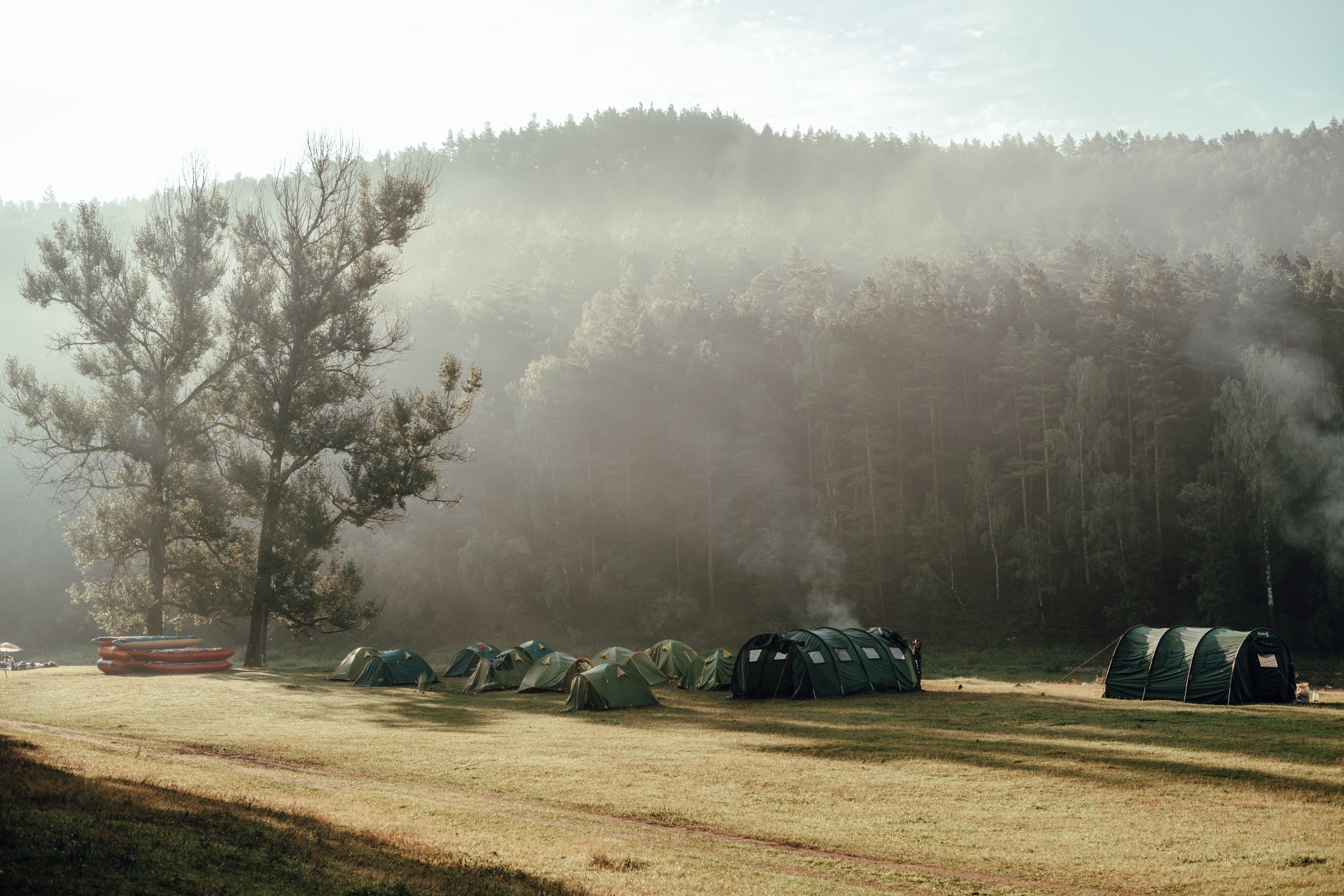 Tents at dawn in a mist-wrapped clearing